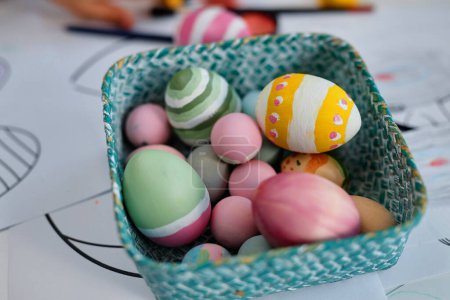 Téléchargez les photos : Gros plan des œufs de Pâques peints n petit panier sur la table dans la classe d'artisanat, espace de copie - en image libre de droit