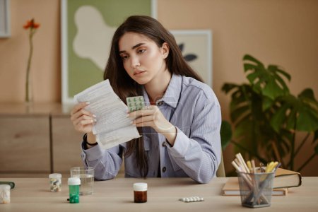 Foto de Retrato de una mujer joven leyendo instrucciones para pastillas recetadas o antidepresivos - Imagen libre de derechos
