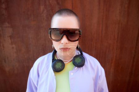 Photo for Waist up portrait of tough young girl wearing sunglasses in urban setting - Royalty Free Image