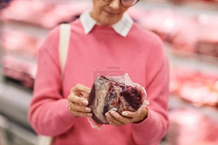 Foto de Primer plano de la mujer que elige la carne fresca durante la compra de comestibles en el supermercado, espacio de copia - Imagen libre de derechos