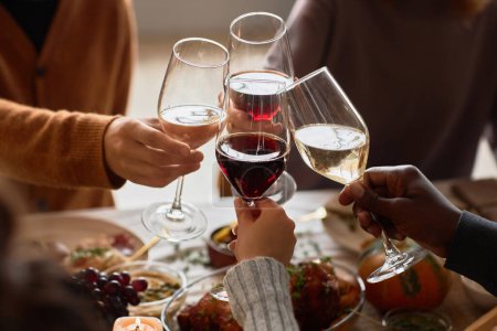 Foto de Primer plano del grupo de personas brindando con copas de vino en la cena festiva celebrando Acción de Gracias juntos, espacio para copiar - Imagen libre de derechos
