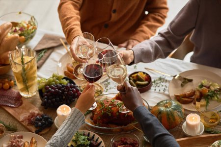 Foto de Diverso grupo de personas brindando con copas de vino en la cena festiva celebrando Acción de Gracias juntos, espacio para copiar - Imagen libre de derechos