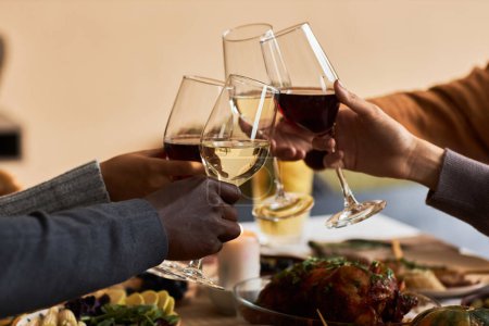 Foto de Primer plano del grupo de personas brindando con copas de vino en celebración en la mesa de cena de Acción de Gracias, espacio para copiar - Imagen libre de derechos