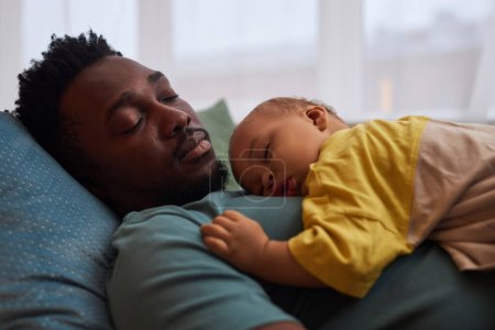 Photo for Side view portrait of exhausted young father falling asleep with cute little baby on chest - Royalty Free Image