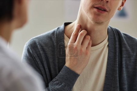 Foto de Primer plano del hombre apuntando a la piel del cuello durante la consulta con el dermatólogo en la clínica, espacio de copia - Imagen libre de derechos