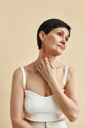 Foto de Retrato mínimo de mujer madura rascarse el cuello con psoriasis punto que sufre de condición de la piel - Imagen libre de derechos
