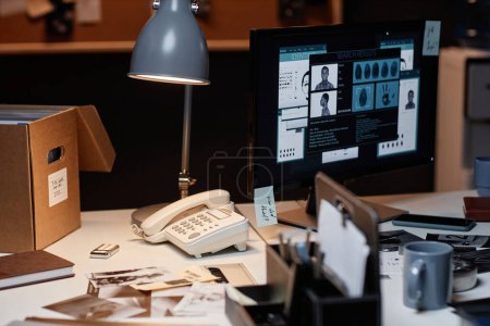 Close up of retro style detectives office with computer on desk lit by lamp, copy space
