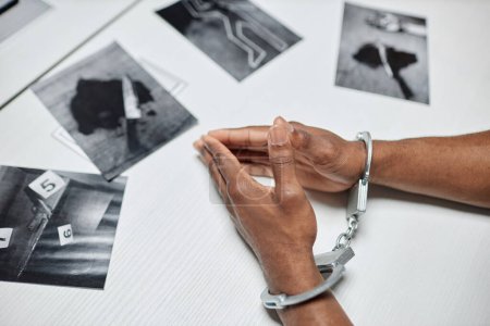 Foto de Vista superior del primer plano de los criminales que llevan esposas en la mesa durante el interrogatorio en el departamento de policía, espacio para copiar - Imagen libre de derechos