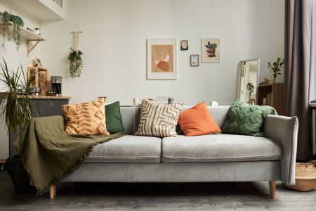 Hintergrundbild des gemütlichen Wohnraums mit Fokus auf bequeme Couch und textiles Dekor, Kopierraum