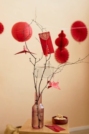 Foto de Minimal background image of tree branches decorated with paper cranes and red envelopes as Chinese New Year tradition Have overflowing abundance every year - Imagen libre de derechos