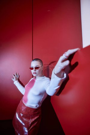 Portrait vertical de mode fisheye de la jeune femme confiante posant en ensemble rouge, espace de copie
