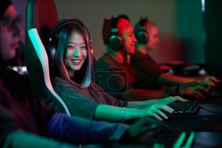 Photo for Portrait of Asian young woman playing video games and smiling at camera in pro cybersports team, copy space - Royalty Free Image
