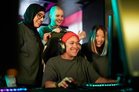Photo for Diverse group of young women playing videogames and cheering for teammate in eSports competition - Royalty Free Image