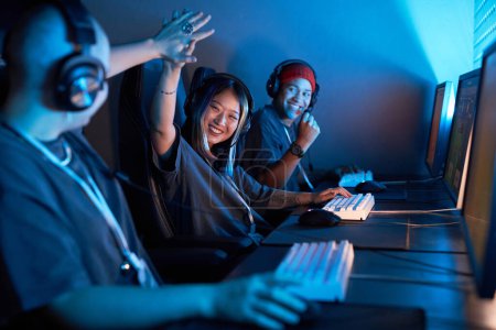 Photo for Portrait of Asian young woman playing video games and celebrating victory in blue light - Royalty Free Image