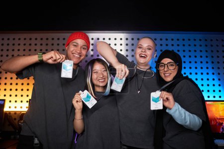 Photo for Portrait of multiethnic female team celebrating victory on stage during competitive eSports event and looking at camera - Royalty Free Image