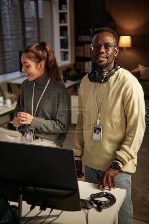 Smiling Black man working as dev team lead in IT company