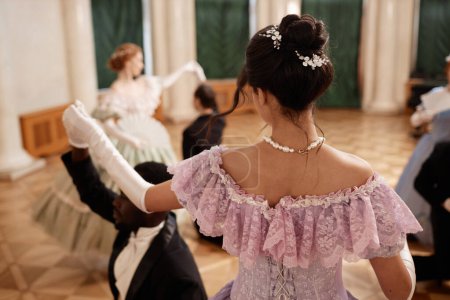 Rückansicht der schönen Dame im Ballkleid, die mit einem Gentleman-Partner im Palastsaal tanzt, Kopierraum