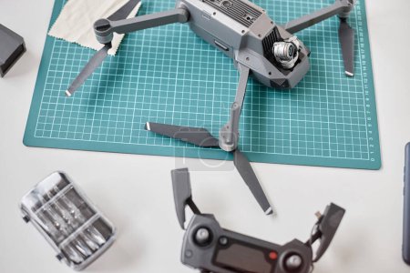 Photo for Top view closeup of quadcopter drone with action camera on table in tech repair shop, copy space - Royalty Free Image