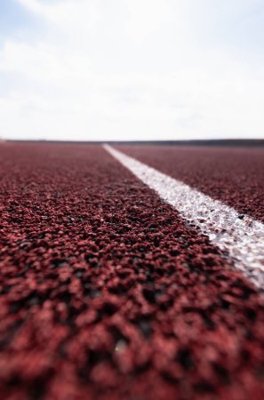 Photo for Close-up of a white lane line on a red running track, with a blurred background. - Royalty Free Image