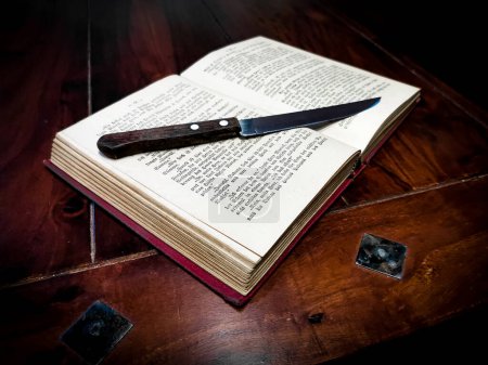 Old knife and a book on the table,detective crime investigation concept