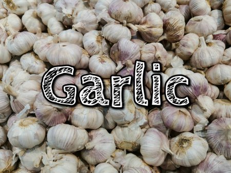 The word garlic on a background of a lot of garlic