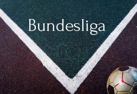 The inscription Bundesliga on the surface of a football field with a ball