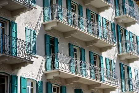 Photo for Windows with balcony on building facade with cast iron ornaments on the street in Italy - Royalty Free Image