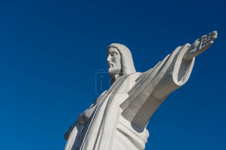 Photo for Detail 12-meter-high statue of Jesus Christ is a copy of a similar sculpture in Rio de Janeiro. Truskavets city, West Ukraine. Large statue of Jesus Christ with outstretched arms against the blue sky - Royalty Free Image