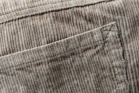 Photo for Texture backdrop of beige colored corduroy fabric cloth with pocket . Corduroy retro fabric background or texture. Close up view - Royalty Free Image