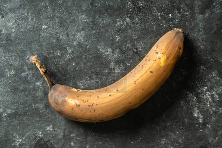 Photo for Brown overripe banana on black background. Close up, top view - Royalty Free Image