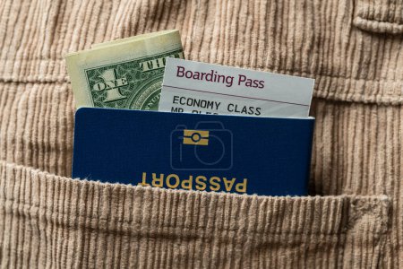 Photo for Dollars, blue passport and boarding pass in the pocket of corduroy pants, close up . Travel concept - Royalty Free Image
