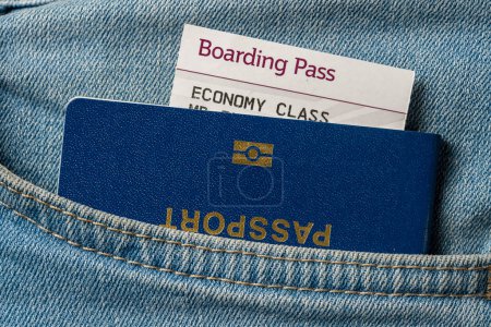 Foto de Pasaporte azul y tarjeta de embarque en sus pantalones vaqueros de bolsillo, de cerca. Concepto de viaje - Imagen libre de derechos