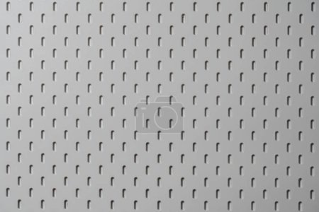 Photo for Perforated white plastic panel for background or texture. Surface with round holes, close up, top view - Royalty Free Image