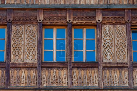 Foto de Ventanas en la fachada de madera de una casa rústica hecha de vigas de madera en una montaña Cárpatos pueblo, oeste de Ucrania, Europa, de cerca - Imagen libre de derechos