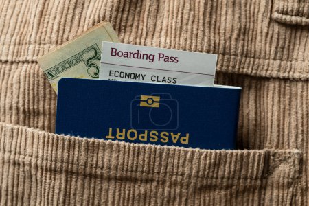 Foto de Dólares, pasaporte azul y tarjeta de embarque en el bolsillo de los pantalones de pana, de cerca. Concepto de viaje - Imagen libre de derechos