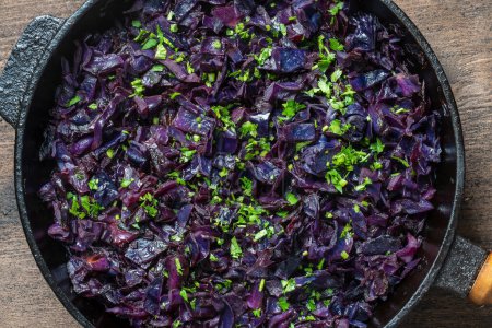Photo for Red cabbage are pan-fried until lightly charred, then braised in mulled wine. Background of fry blue cabbage in a section, macro. Close up, top view. Texture and pattern of purple cabbage - Royalty Free Image