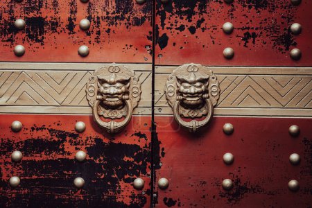 Foto de Vintage puerta golpeador maneja estilo asiático en las puertas pintadas de rojo. León manija de la puerta anillos de cerca - Imagen libre de derechos