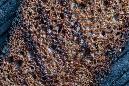 Foto de Deep fried toast bread on a black cast-iron grill pan, close-up, top view, macro - Imagen libre de derechos
