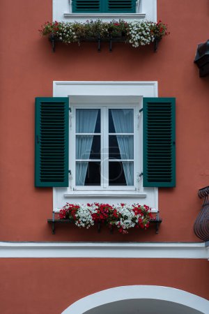 Téléchargez les photos : Window on the red wall facade with open green color classic shutters, Austria, close up - en image libre de droit