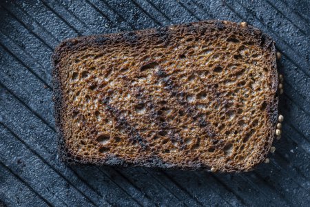 Photo for Deep fried toast bread on a black cast-iron grill pan, close-up, top view, macro - Royalty Free Image