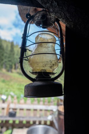 Photo for Single old kerosene lantern hanging in the yard in a mountain village, in the Carpathians, Ukraine, close up - Royalty Free Image