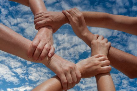 Téléchargez les photos : Many hands of people connect or link together community of cooperation on blue sky background, close up. Team support concept - en image libre de droit