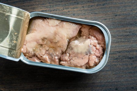 Photo for Open tin can with cod liver on wooden table background, close up, top view - Royalty Free Image