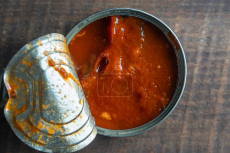 Téléchargez les photos : Sprats ouverts en conserve en sauce tomate sur fond bois, gros plan, vue sur le dessus - en image libre de droit