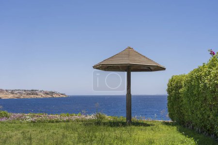 Foto de Playa vacía con sombrilla de madera en complejo tropical en la costa del Mar Rojo en Sharm El Sheikh, Egipto, África. Naturaleza y concepto de viaje - Imagen libre de derechos