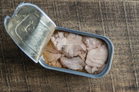 Photo for Open tin can with cod liver on wooden table background, close up, top view - Royalty Free Image