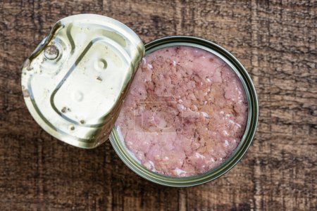 Photo for Open canned tuna in oil sauce on a wooden background, close up, top view - Royalty Free Image