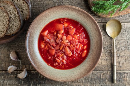 Photo for Ukrainian national dish red borsch in a ceramic plate on a wooden background. Beetroot soup is a national dish in Ukraine, close up, top view - Royalty Free Image