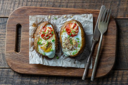 Photo for Baked potatoes stuffed with cheese, tomato, green onion and eggs on wooden background, top view, close up - Royalty Free Image