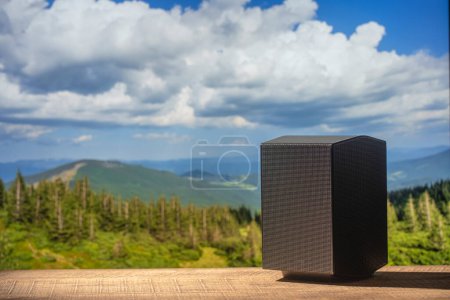 Téléchargez les photos : Haut-parleur acoustique noir sur une table en bois sur fond de montagnes des Carpates en Ukraine. L'équipement musical, gros plan - en image libre de droit